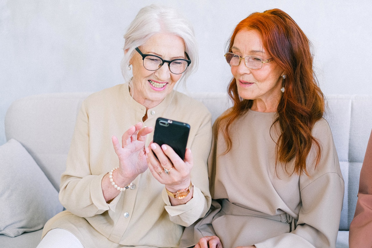 An image of a younger woman helping an older woman with technology
